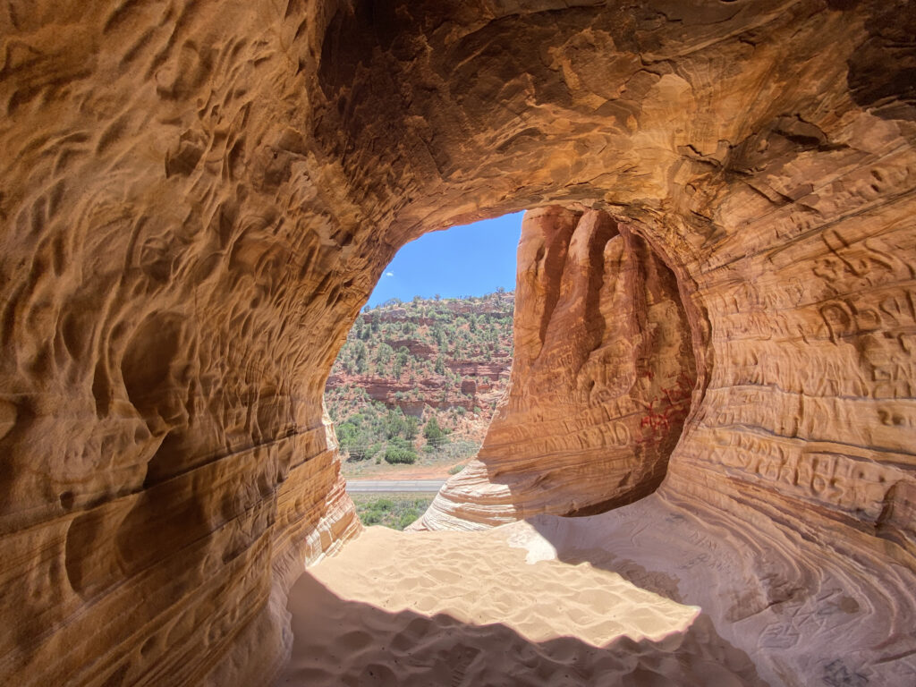 Sand Cave opening framing blue sky near Kanab